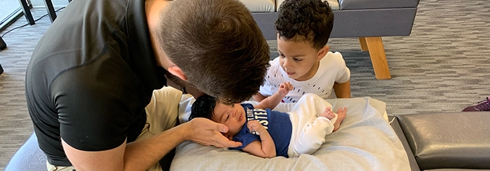 Chiropractic Edina MN Doctor Adjusting Baby With Boy Chiropractic Edina MN Doctor Adjusting Baby With Boy